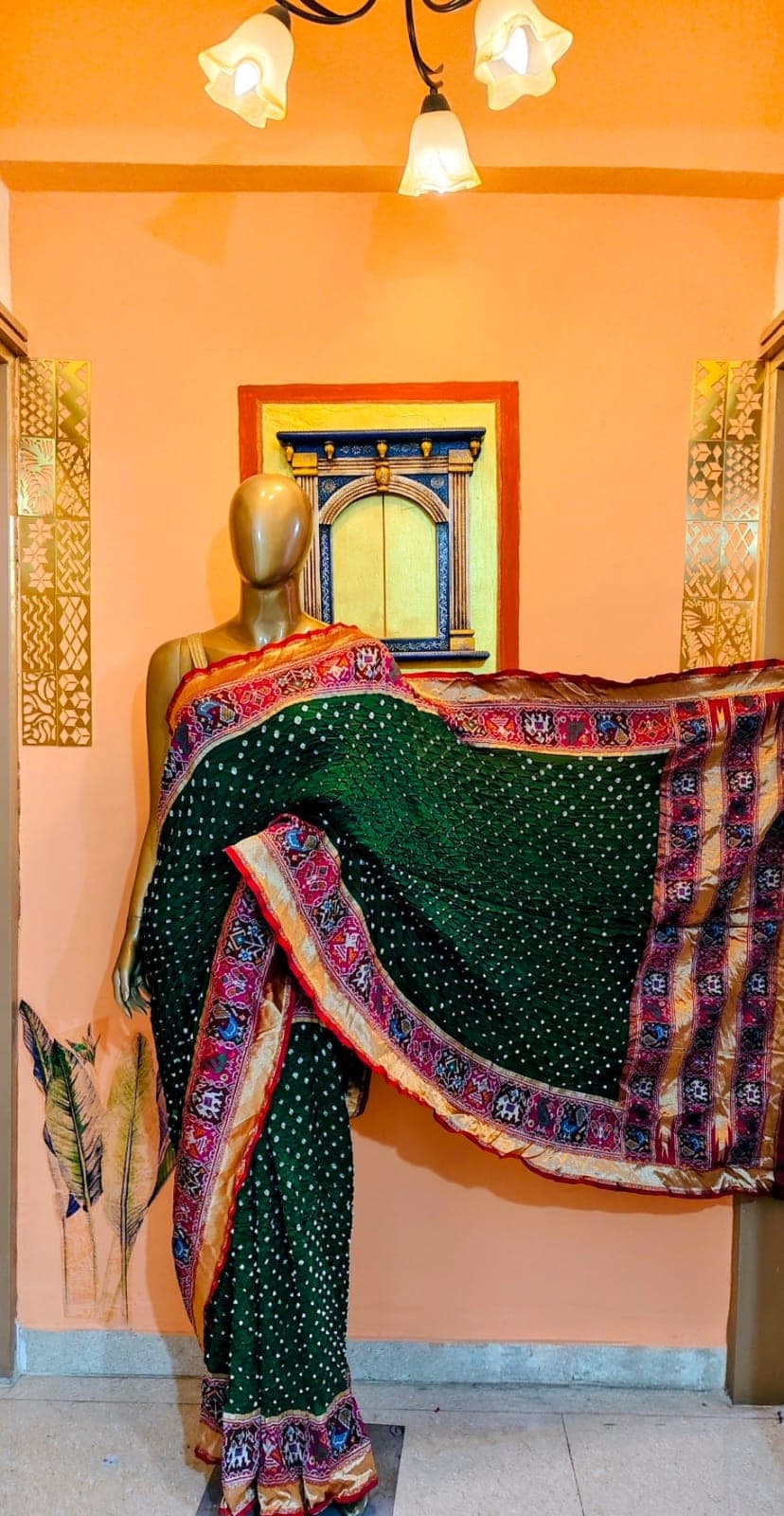 Emerald saree with a figured border, on a stand